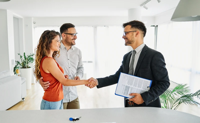 Couple shaking hands with real estate agent