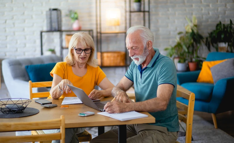 Senior couple using laptop at home