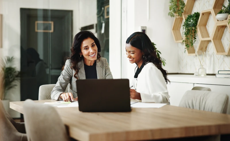 Two women collaborating at a laptop
